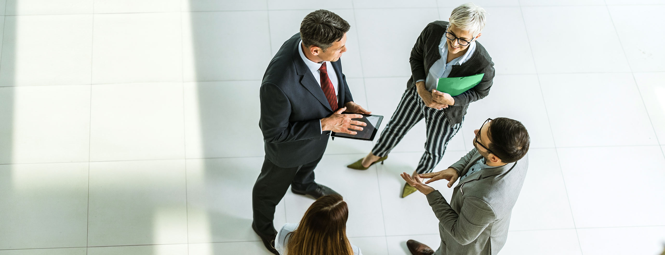 Businessmen and women standing in a circle talking to each other