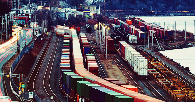 Several cargo containers on a freight train in a rail yard
